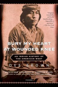 Cover of 'Bury My Heart at Wounded Knee: An Indian History of the American West' by Dee Brown, recognized as one of the best books on American history, featuring a solemn image of Native American warriors on horseback.