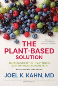 Cover of 'The Plant-Based Solution' by Joel Kahn, M.D. with a heart design made of vegetables.