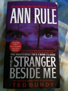 Cover of 'The Stranger Beside Me' by Ann Rule with a haunting portrait of Ted Bundy.